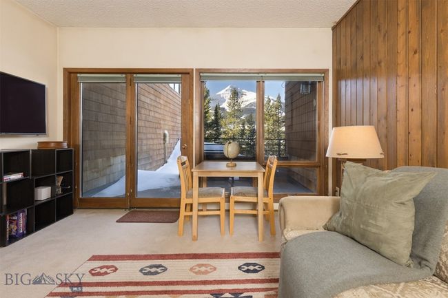 Living room with carpet flooring, a mountain view, a textured ceiling, and wooden walls | Image 19