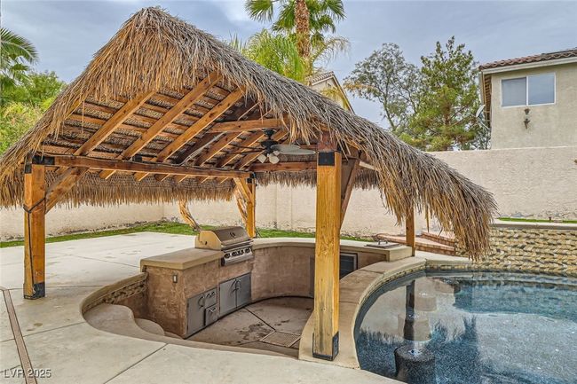 Fenced backyard featuring a gazebo, exterior kitchen, and a patio | Image 43