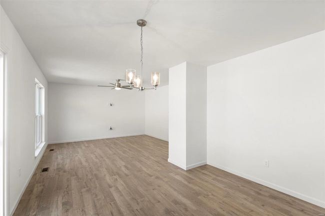 Empty room featuring hardwood / wood-style floors and an inviting chandelier | Image 16