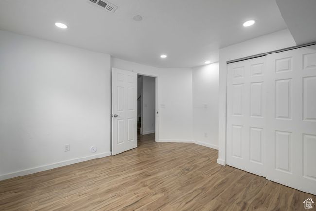 Basement bedroom featuring recessed lighting, visible vents, light wood-type flooring, and baseboards | Image 24