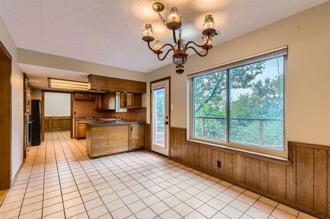 Kitchen opens to single dining, pedestrian door leading to deck | Image 11