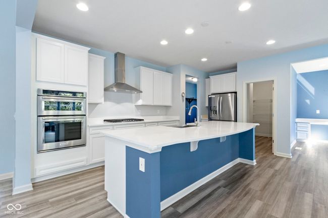 Upgraded kitchen with all of the bells and whistles. Large gas cooktop, built in microwave/oven combo, stainless steel range hood and huge island with seating for four. | Image 18