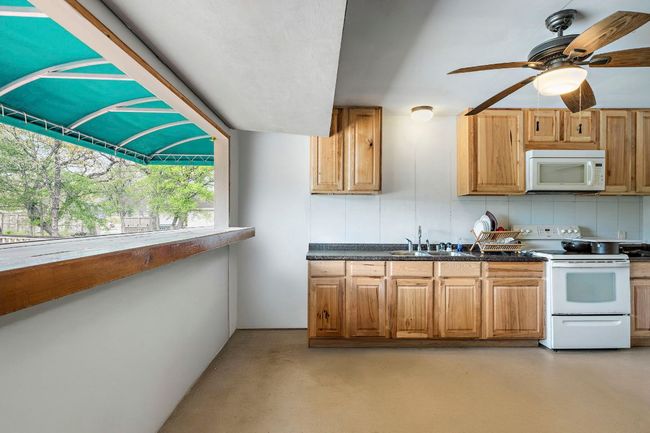 Full kitchen in pool house opens to pool deck. | Image 36