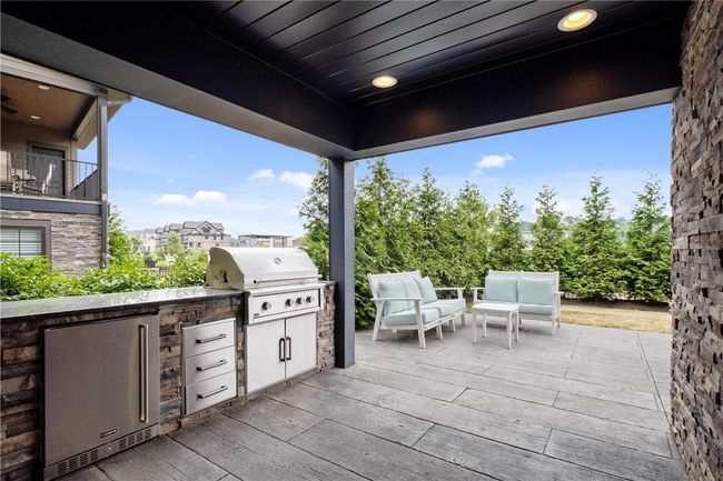 Lower Level rear patio has built-in trash, grill, storage drawers, and mini fridge! | Image 43