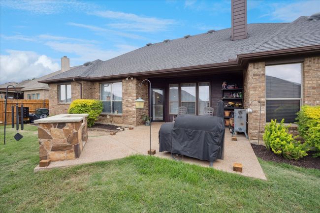 Back of property with a chimney, a patio area, a shingled roof, and brick siding | Image 24