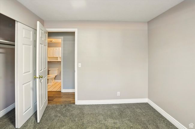 Unfurnished bedroom with carpet flooring, baseboards, and a closet | Image 20