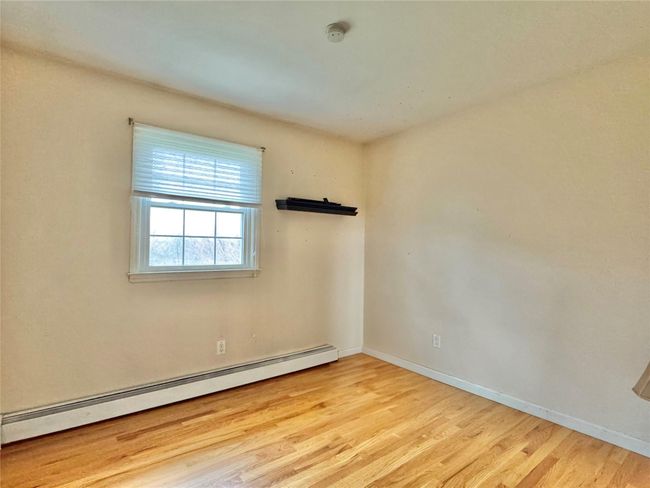 Spare room with a baseboard radiator, wood finished floors, and baseboards | Image 14
