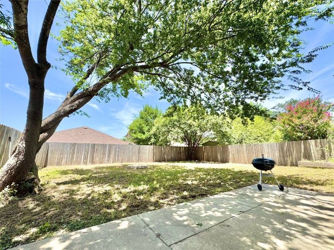 Fenced backyard with a patio area and grilling area | Image 17