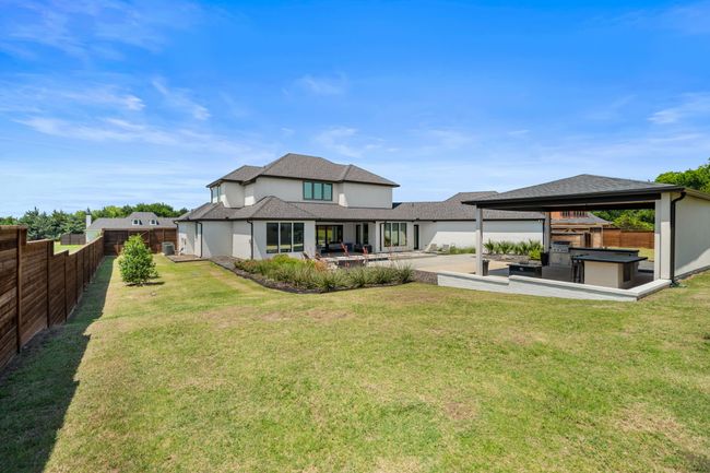 Rear view of property with a gazebo, a patio, a shingled roof, stucco siding, and exterior kitchen | Image 37