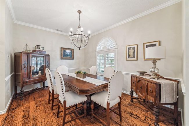The dining room features elegant custom lighting and seamlessly connects to the kitchen and family room. | Image 6