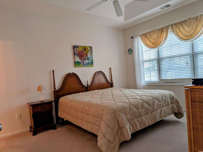 Carpeted bedroom featuring baseboards, ceiling fan, and visible vents | Image 10