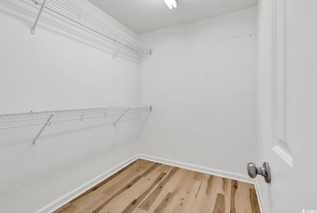 Spacious closet featuring light wood-style flooring | Image 14