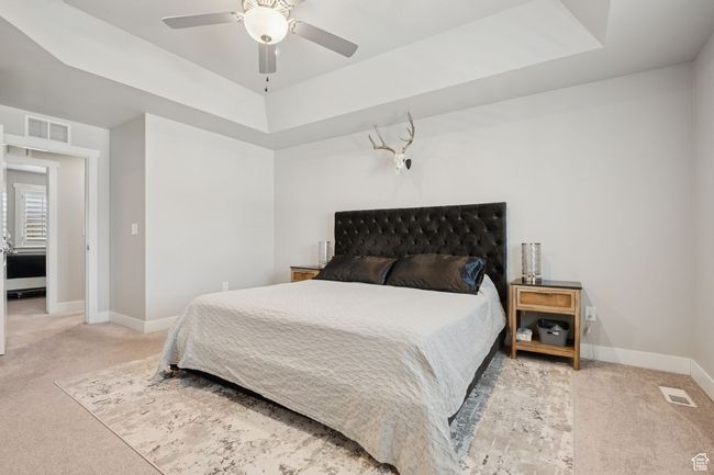 Carpeted bedroom with a raised ceiling and a ceiling fan | Image 18