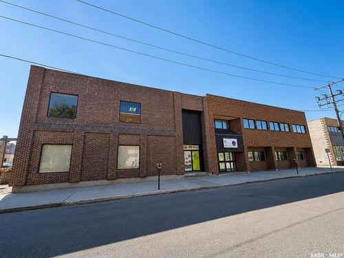 Two-story commercial building featuring a brick exterior and multiple window styles | Card Image
