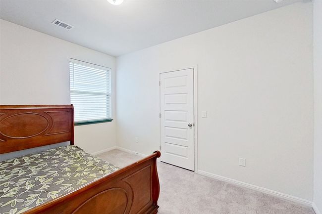 Bedroom featuring baseboards, visible vents, and light carpet | Image 33