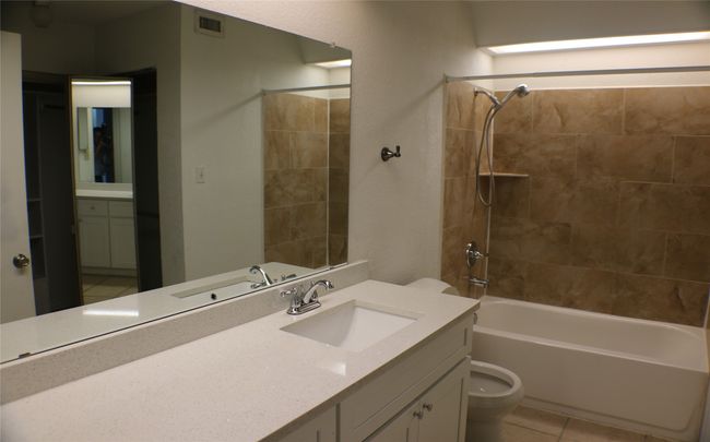 Bathroom with vanity, shower / tub combination, and tile patterned flooring | Image 10
