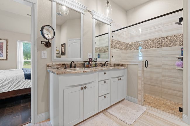 Full bath featuring double vanity, a shower stall, and ensuite bath | Image 18
