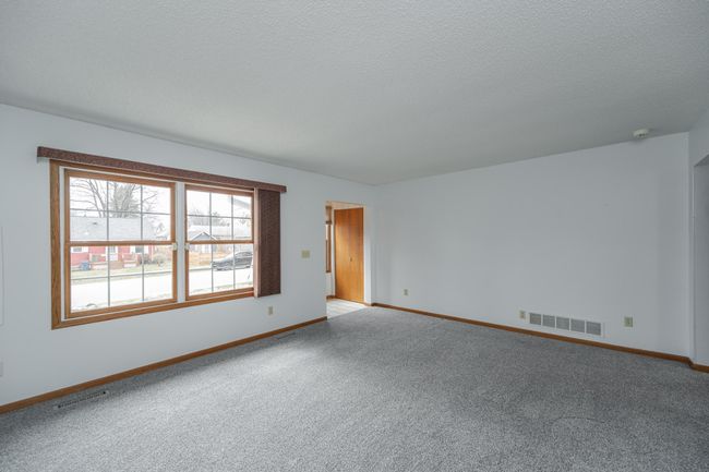 Bright foyer and front living room with neutral carpeting. | Image 5