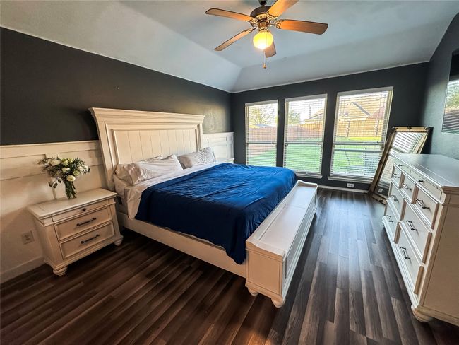 Bedroom with dark wood-type flooring, ceiling fan, and vaulted ceiling | Image 11