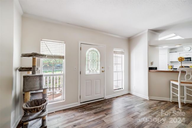 The foyer greets you with natural light, lovely laminate wood floors and neutral paint color. | Image 5