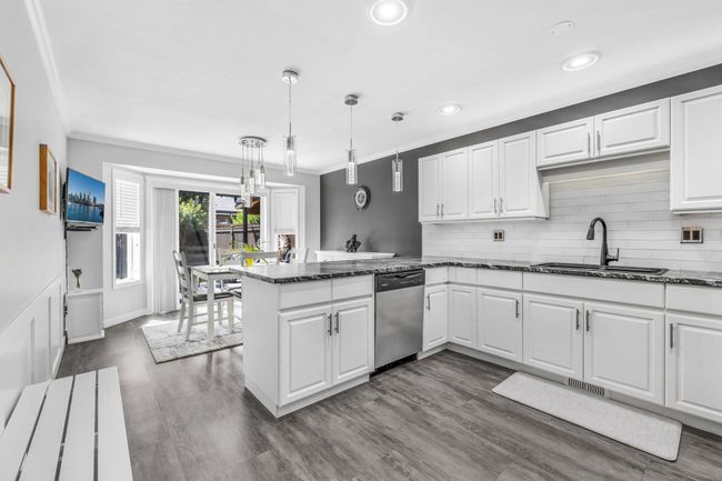 Kitchen featuring dishwasher, a sink, ornamental molding, and white cabinets | Image 11