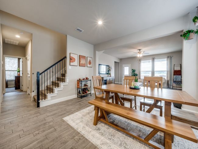 Centrally located, this open dining space offers effortless flow between the kitchen, living room, and nearby staircase. | Image 10