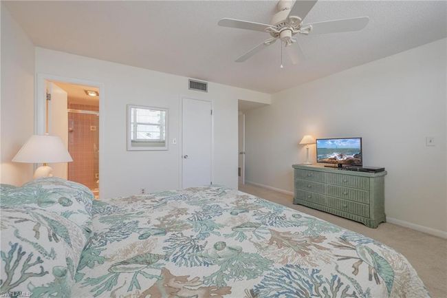 Carpeted bedroom with ceiling fan and ensuite bath | Image 21