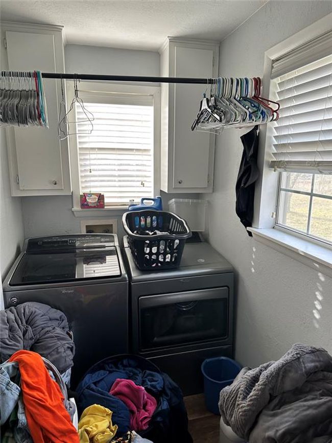 Clothes washing area featuring washer and dryer, cabinet space, and a textured ceiling | Image 27