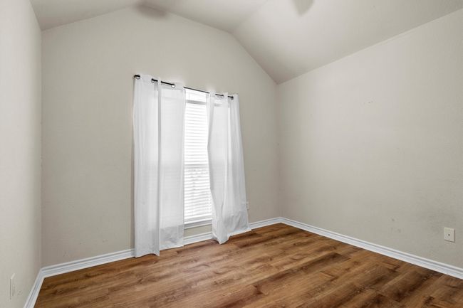 Spare room featuring lofted ceiling and wood finished floors | Image 27