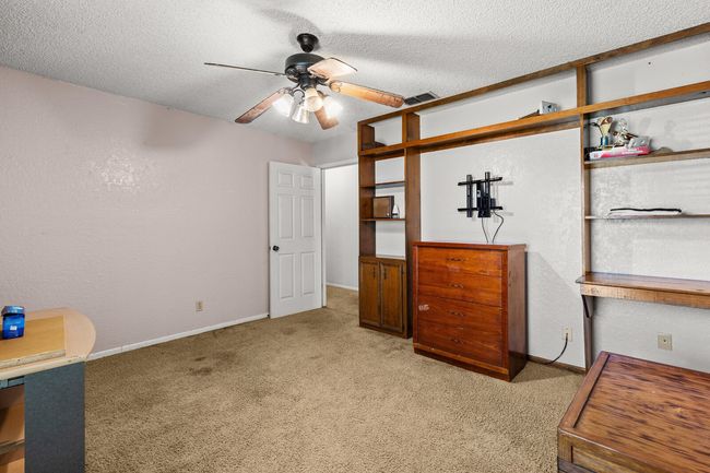 Unfurnished bedroom featuring light carpet, baseboards, visible vents, and a textured ceiling | Image 13