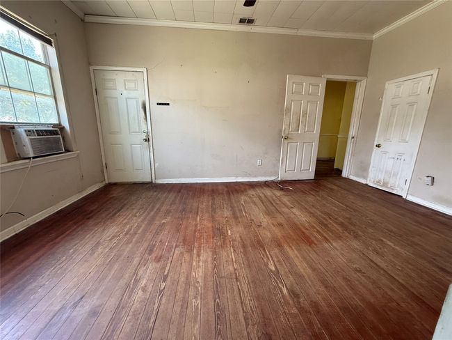 Spare room with crown molding, hardwood / wood-style flooring, cooling unit, and baseboards | Image 12