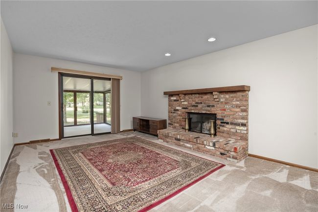 Carpeted family room with a brick fireplace | Image 13