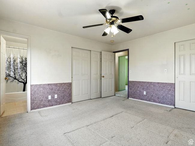 Unfurnished bedroom with a wainscoted wall, ensuite bathroom, and a ceiling fan | Image 17