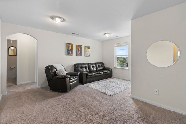 Carpeted living area with baseboards, visible vents, and arched walkways | Image 21