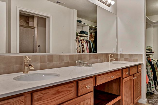 Full bathroom featuring a spacious closet, double vanity, and tasteful backsplash | Image 6