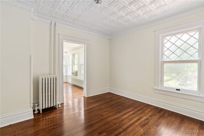Bedroom with radiator, radiator heating unit, an ornate ceiling, plenty of natural light, and wood flooring | Image 32