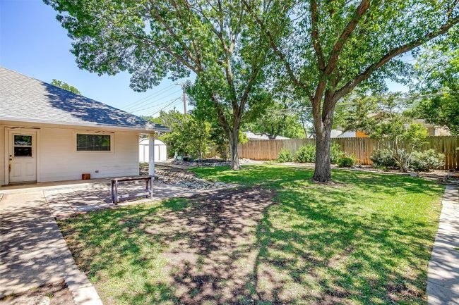View of yard with fence, a storage shed, and a patio | Image 34
