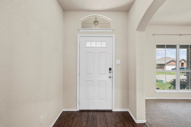 Foyer featuring arched walkways, healthy amount of natural light, and dark wood-style flooring | Image 6