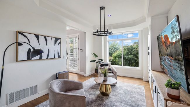 This elegant living space features a beautiful open layout, perfect for relaxing as soon as you walk in, with plenty of room to customize with your choice of furniture and a large window that fills the room with natural light | Image 8