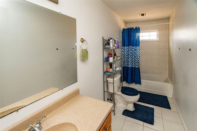 Bathroom featuring vanity, visible vents, shower / tub combo, tile patterned floors, and toilet | Image 37