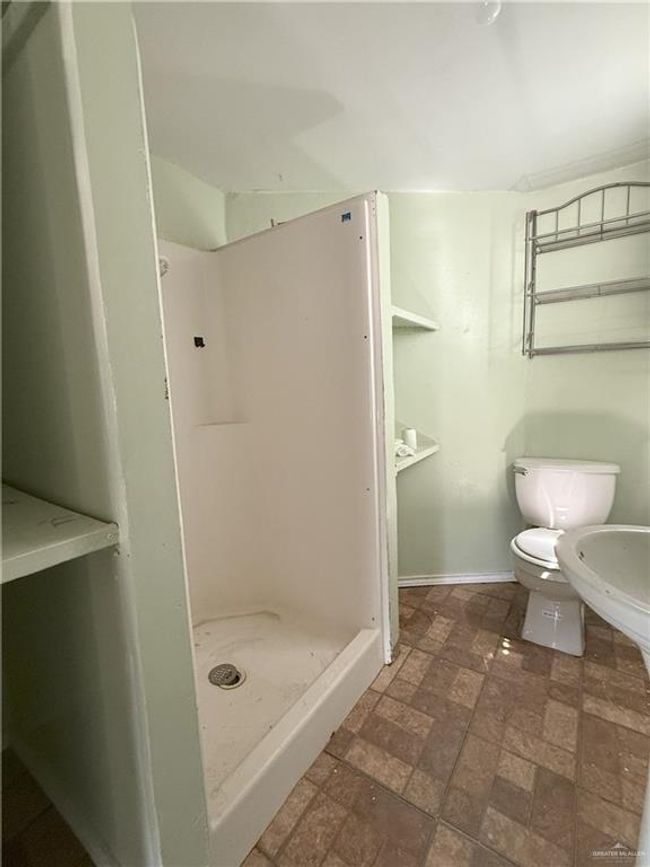 Full bath featuring baseboards, a stall shower, and toilet | Image 7
