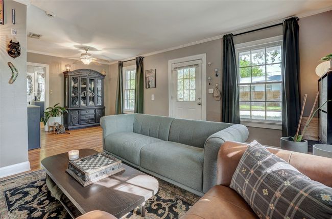 Living room featuring wood finished floors, a ceiling fan, and ornamental molding | Image 8