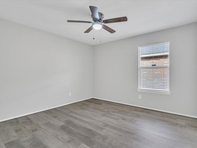 Spare room featuring wood finished floors, ceiling fan, and baseboards | Image 15