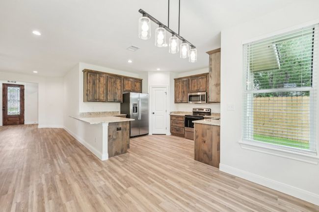 Kitchen with a peninsula, plenty of natural light, visible vents, and appliances with stainless steel finishes | Image 16