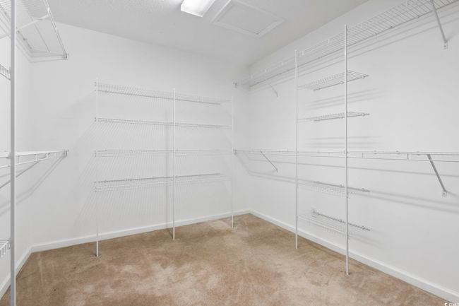 Walk in closet with carpet flooring and attic access | Image 19