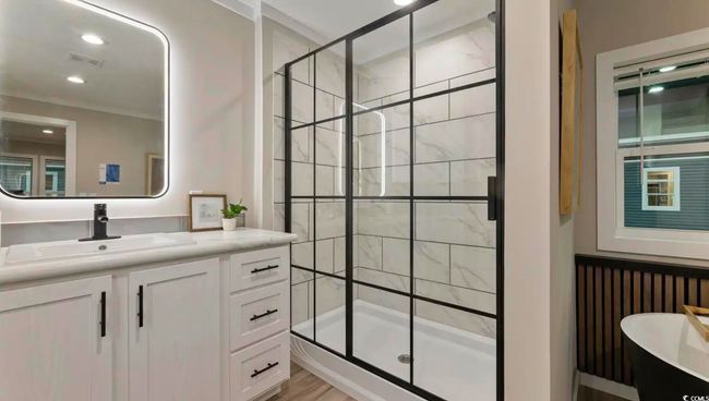 Bathroom with a stall shower, vanity, and a freestanding tub | Image 26
