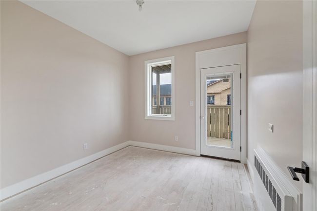 Unfurnished room with light wood finished floors, radiator heating unit, and baseboards | Image 39