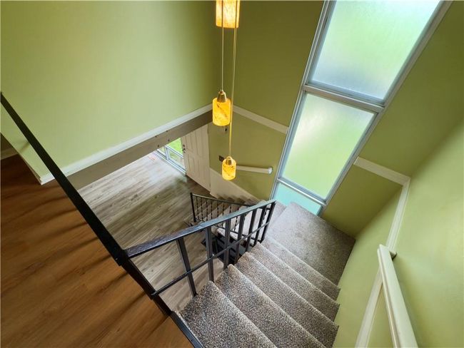 Stairway featuring a wealth of natural light, wood finished floors, and baseboards | Image 9