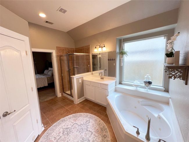 Primary bathroom with shower and jetted tub. There's a second sink and vanity. | Image 16