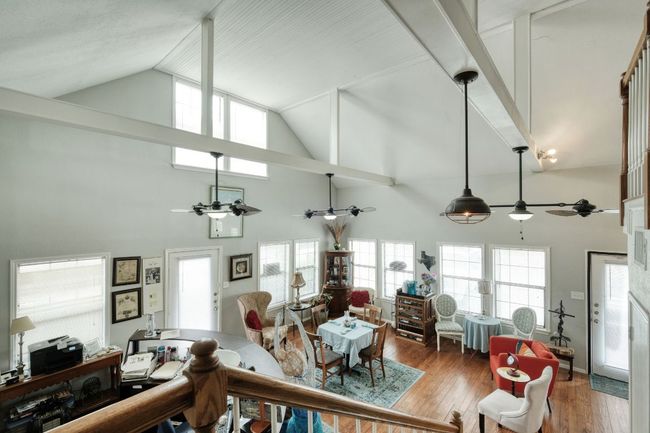 Living area featuring ceiling fan, high vaulted ceiling, plenty of natural light, and wood finished floors | Image 5